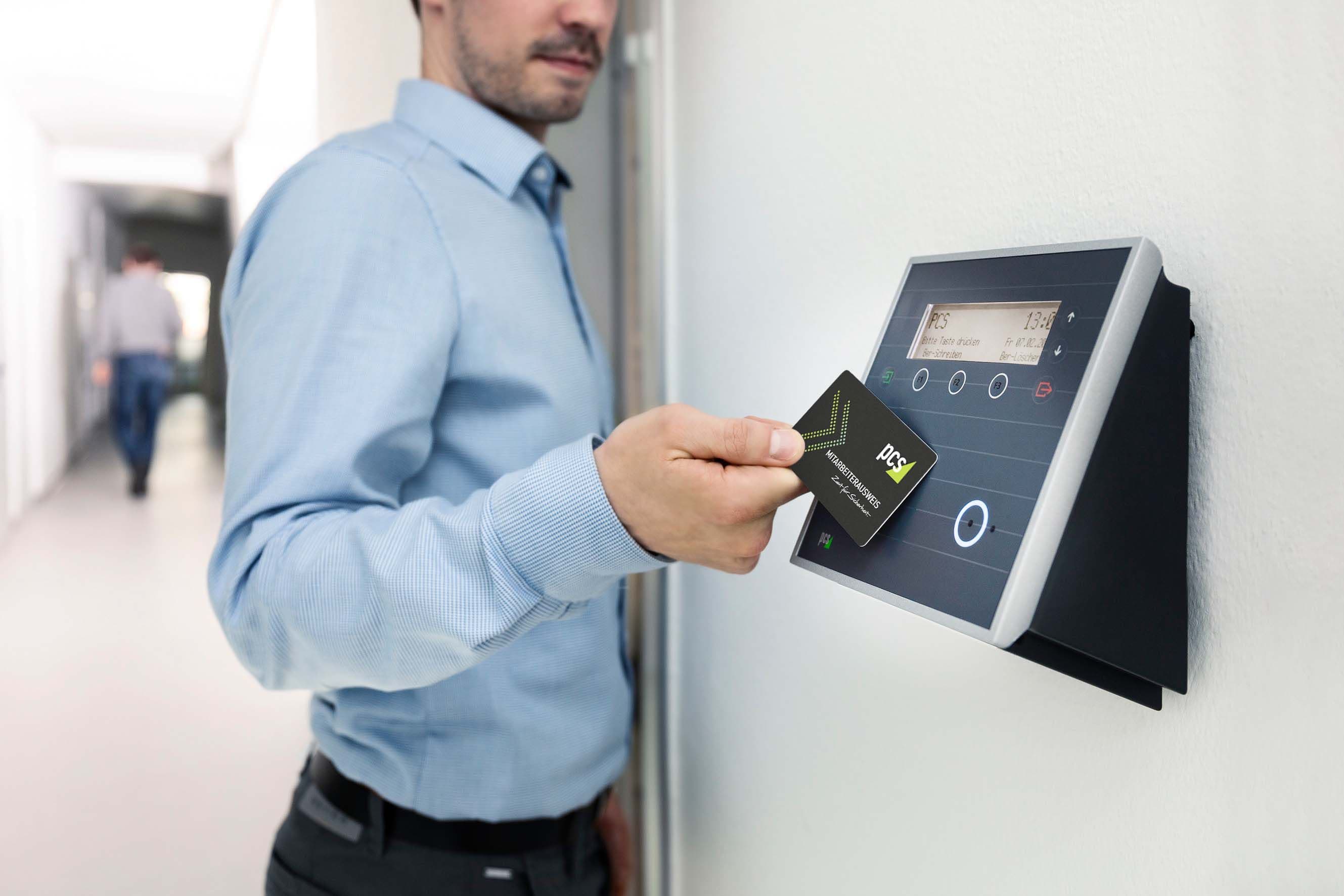 Employee tapping an access card on a wall-mounted access control reader